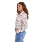 A woman in profile modelling a cream Wrangler Women's Ivory Long Sleeve Shirt (X6S2103602) with a western novelty print paired with kora blue Wrangler Women's Margo Trouser Jeans Willow (XCP2253710) and a Wrangler Silvie Belt (X6S2920BLT), against a plain white studio background.