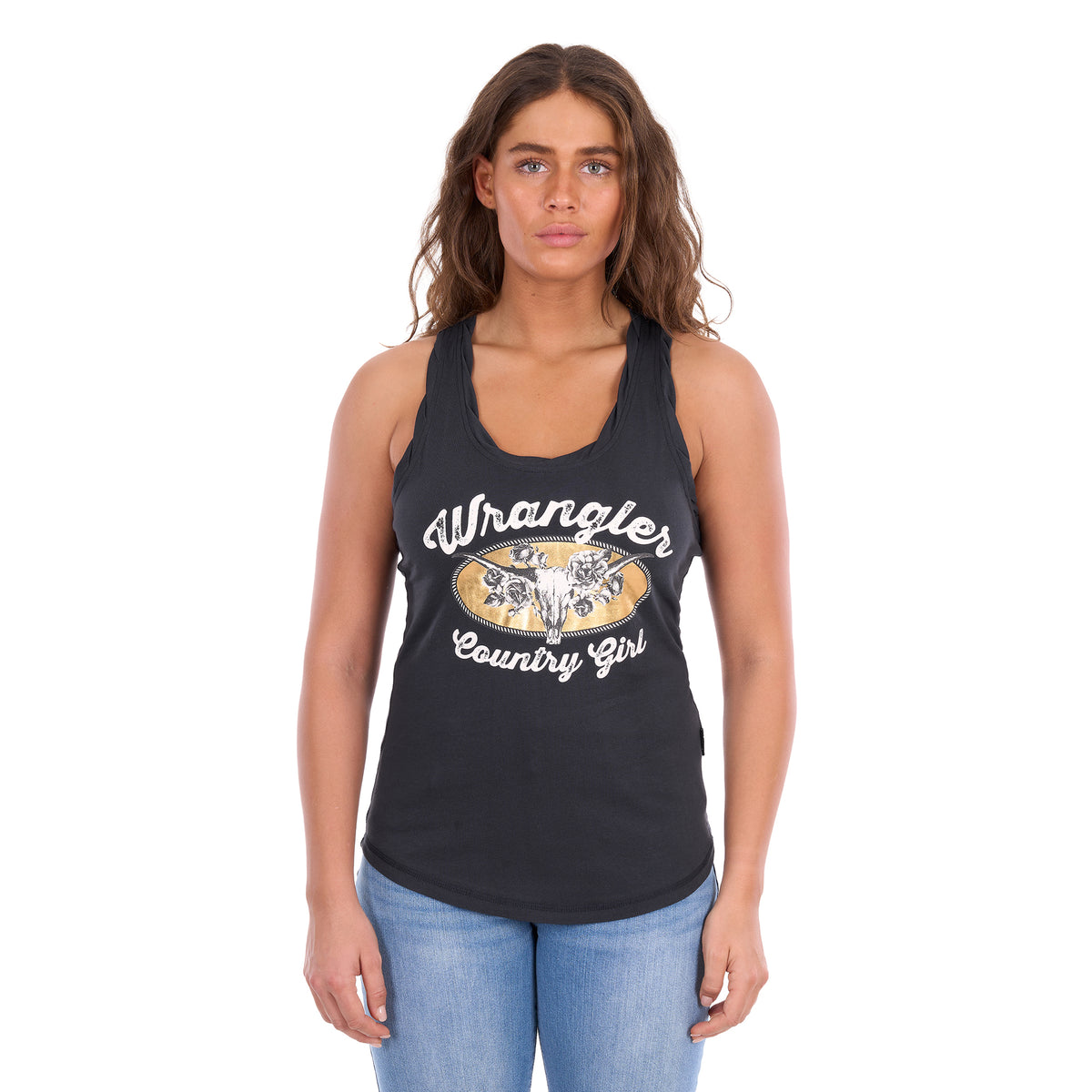A woman modelling a charcoal Wrangler Women's Jasmine Tank (X6S2508648) with racerback, featuring 'Wrangler Country Girl' graphic on the front, paired with light blue jeans, against a plain white background.