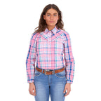 A woman modelling a pink, blue, and white plaid Wrangler Kiara Long Sleeve Shirt (X6S2105603) with kora blue Wrangler Margo Trouser Jeans Willow (XCP2253710) and a light tan Wrangler Silvie Belt (X6S2920BLT), photographed against a solid white background.