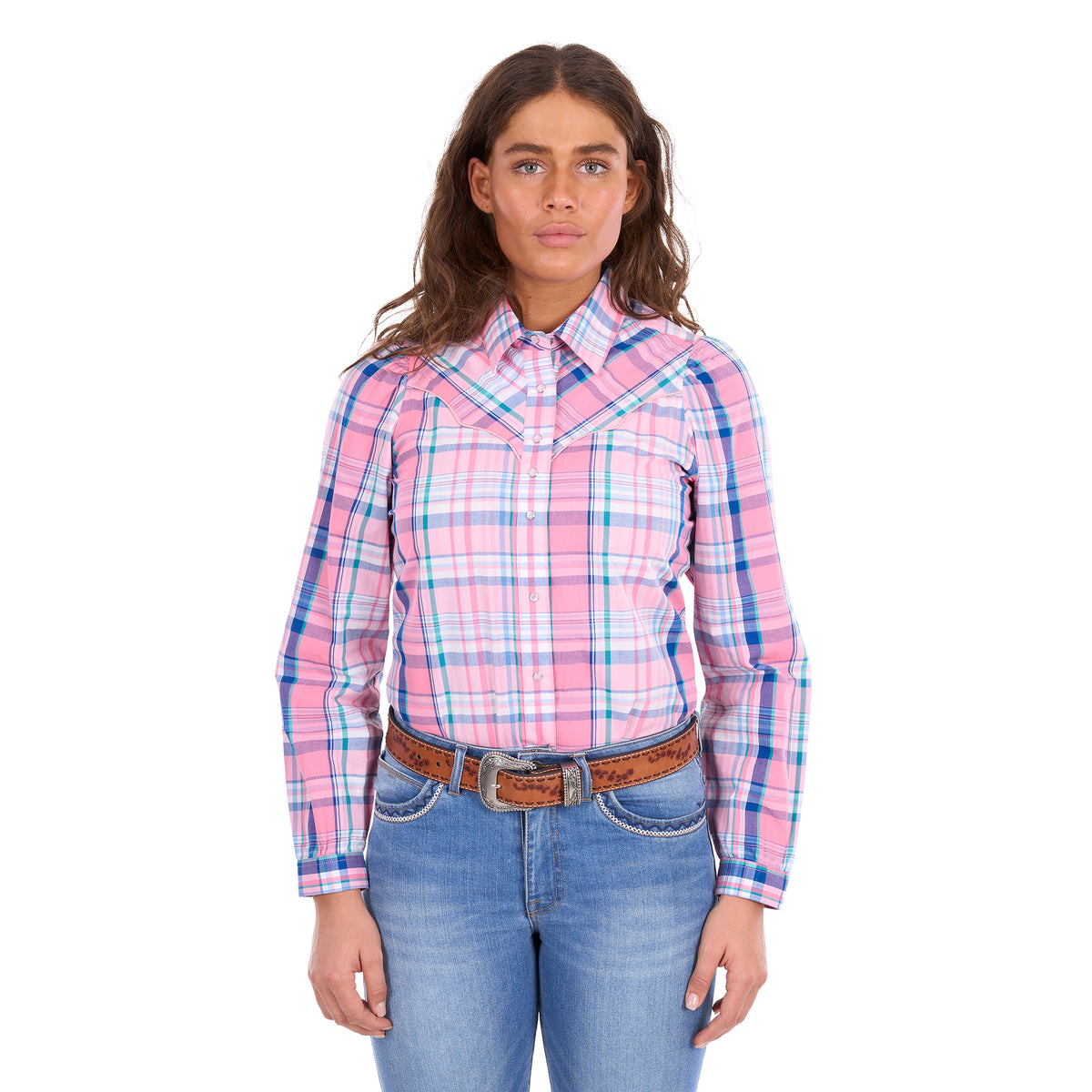 A woman modelling a pink, blue, and white plaid Wrangler Kiara Long Sleeve Shirt (X6S2105603) with kora blue Wrangler Margo Trouser Jeans Willow (XCP2253710) and a light tan Wrangler Silvie Belt (X6S2920BLT), photographed against a solid white background.