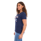 A woman viewed in profile modelling a navy blue Wrangler Women's Lana V-Neck T-Shirt (X6S2599634) with a western graphic on the chest, paired with light blue jeans, against a plain white background.