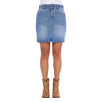 A faded blue Wrangler Women's Maisy Denim Skirt (XCP2409723) shown on a model from the waist down, paired with a white top and tan cowboy boots, against a plain white background.