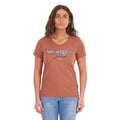 A woman modelling a Wrangler Women's Maya V-Neck S/S Tee (X6S2599640) in Copper, featuring Wrangler lace applique and embroidery with metallic detail across the chest, paired with blue jeans against a plain white background.