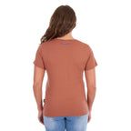 A woman viewed from the back modelling a Wrangler Women's Maya V-Neck S/S Tee (X6S2599640) in Copper, featuring Wrangler logo on the back neck, paired with blue jeans against a plain white background.