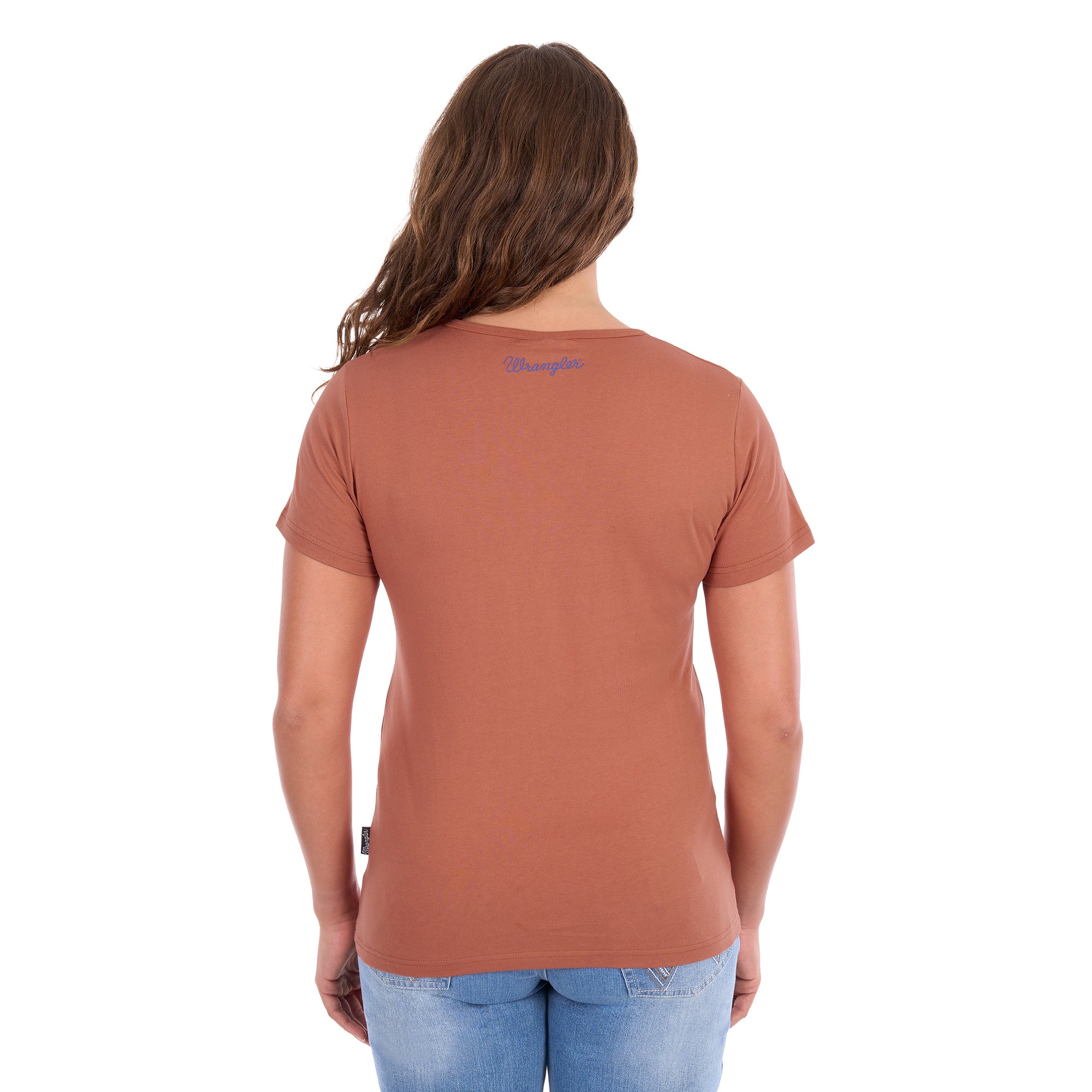 A woman viewed from the back modelling a Wrangler Women's Maya V-Neck S/S Tee (X6S2599640) in Copper, featuring Wrangler logo on the back neck, paired with blue jeans against a plain white background.
