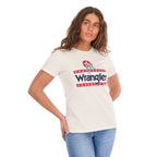 A woman modelling a Wrangler Women's Nora Short Sleeve Tee (XCP2598636) in cream, featuring a red, white, and navy blue graphic logo on the chest, paired with blue jeans against a plain white background.