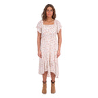A woman modelling a cream Wrangler Women's Renee Short Sleeved Dress (X6S2407621) with a square neckline and a delicate western floral print on a light cream background, paired with brown ankle boots, set against a plain white background.
