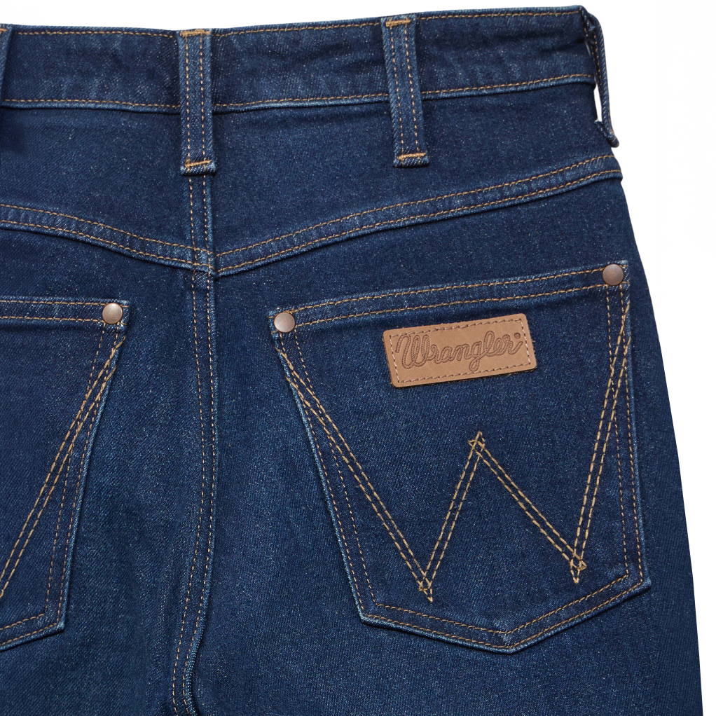 Close up back pocket detail on a pair of flat laid Kayla blue Wrangler Women's Rodeo Bootcut Jeans (112367606) on a white studio background.