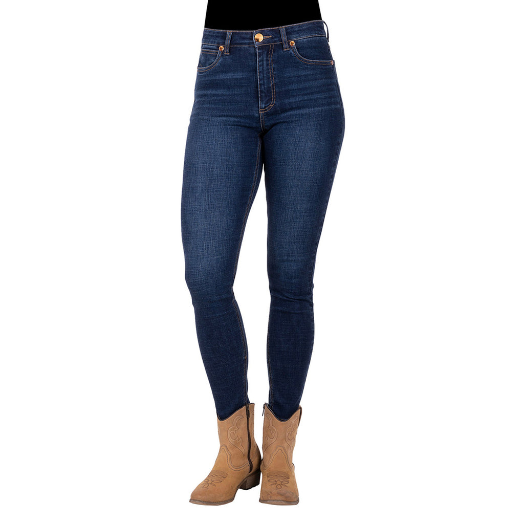 Front view of a person wearing old indigo blue Wrangler Women's Sierra Skinny Jeans (XCP2238861) with tan cowboy boots against a plain white background.