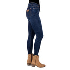 Profile view of a person wearing old indigo blue Wrangler Women's Sierra Skinny Jeans (XCP2238861) with tan cowboy boots against a plain white background.