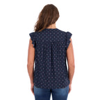 A woman viewed from behind modelling a navy blue Wrangler Women's Sofia Short Sleeve Blouse (X6S2503617) with a small repeating geometric pattern and ruffled cap sleeves, paired with blue jeans against a plain white background.