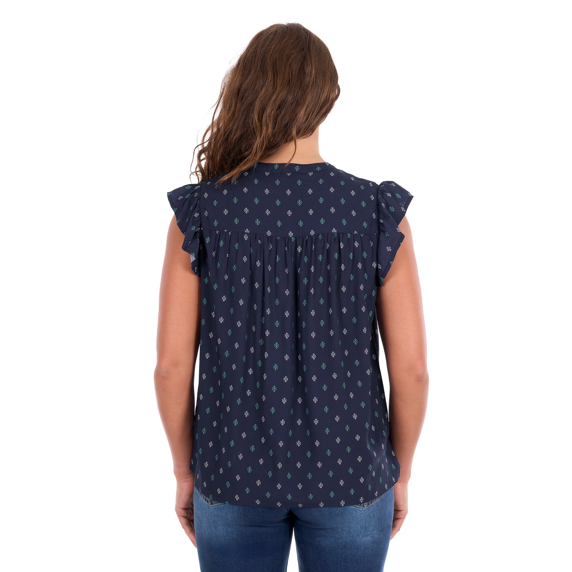 A woman viewed from behind modelling a navy blue Wrangler Women's Sofia Short Sleeve Blouse (X6S2503617) with a small repeating geometric pattern and ruffled cap sleeves, paired with blue jeans against a plain white background.