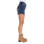 A model in profile wearing old indigo blue Wrangler Women's Summer High Rise Denim Shorts (XCP2412718) and tan cowboy boots, shown from the waist down on a plain white background.