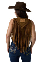 A woman shown from the back wearing a brown suede fringe vest with braided trim, a matching brown cowboy hat, and blue jeans against a white studio background.